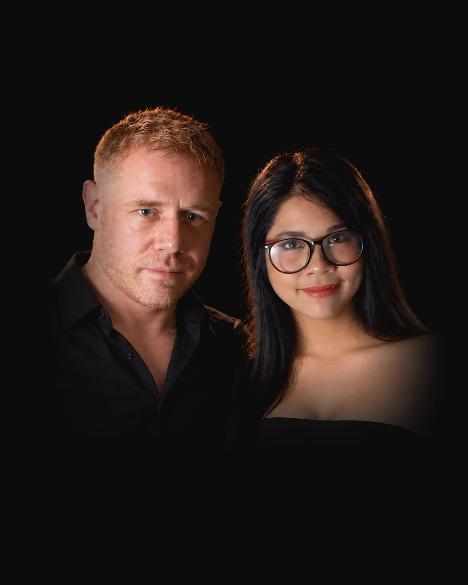 Tim and Paemi, who run Pattaya After Dark, side by side in black.